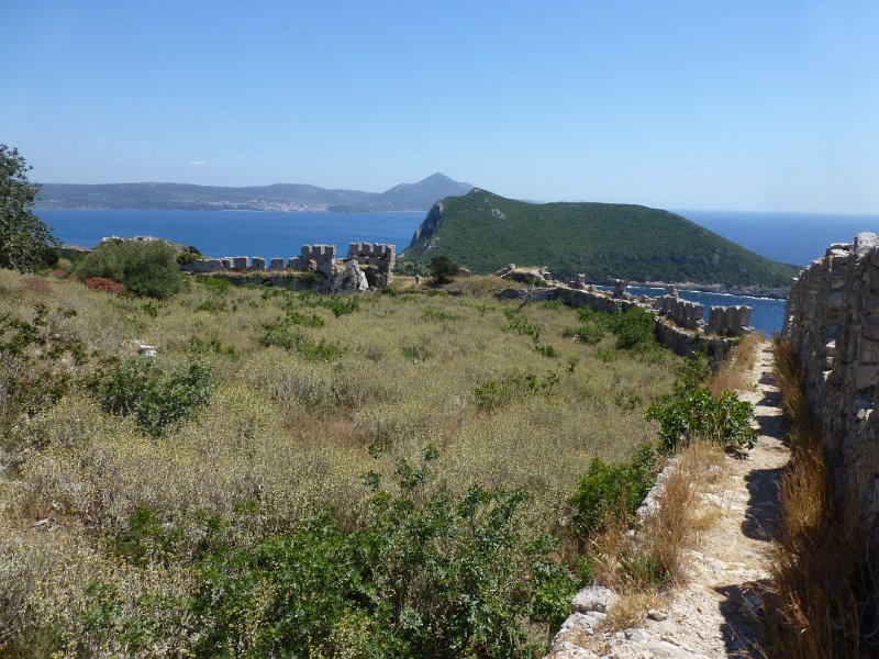 P1090170.JPG - Uitzicht vanuit het paleokastro op de baai. Het eiland rechts was van Sparta. Het witte dorple op de achtergrond is Pylos.