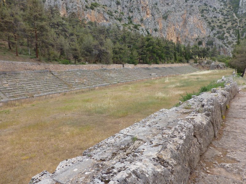 P1090486.JPG - Ook in Delphi werden eens in de vier jaar Spelen gehouden. Bijna net zo belangrijk als de Olympische spelen. Logisch: hier wel zitplaatsen! Het stadion ligt helemaal bovenaan het complex - de sporters (en toeschouwers) gingen eerst langs de tempels. 