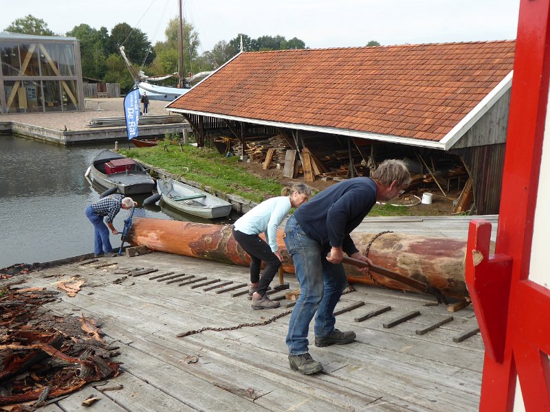 P1090187.JPG - De boom voor de deuropening rollen. Onderaan de molenaar, Simon Jellesma. Annet en Willem zijn vrijwilligers. Het is Annets eerste  dag.
